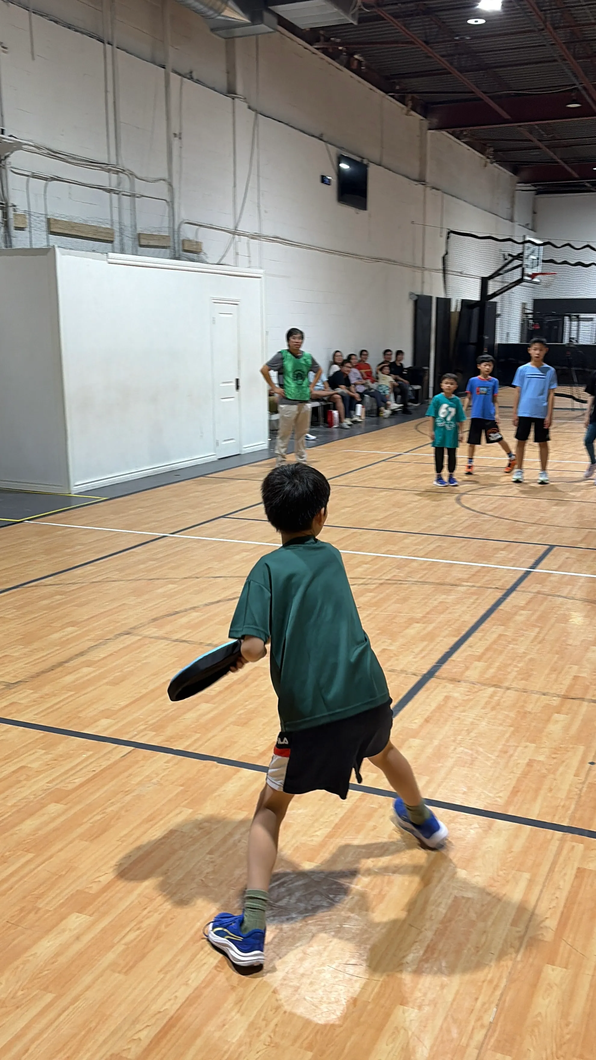 A young Dodgebee player prepares to throw a soft disc during an indoor game.